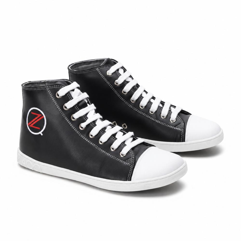 Ein Paar klassischer schwarzer High-Top-Sneaker von ZAQQ CHUQQS hat weiße Schnürsenkel und Zehenkappen, die jeweils ein auffälliges rot-weißes Z-Logo zeigen. Die Sohlen bestehen aus strapazierfähigem Kautschuksohle-Gummi, was den Schuhen einen trendigen, leicht abgewetzten Look verleiht.