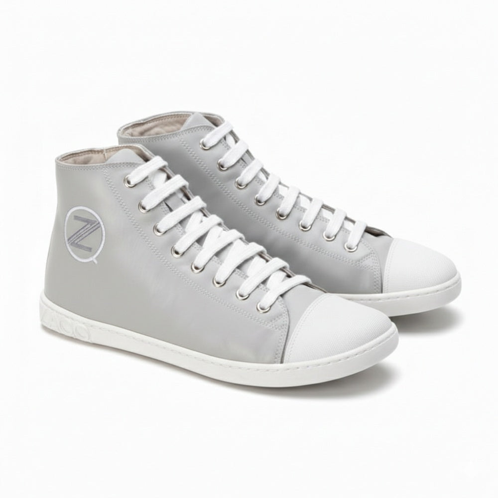 Die stylischen CHUQQS Grey High-Top-Sneaker von ZAQQ zeichnen sich durch ein markantes Z-Logo und eine dezent abgenutzte Sohle aus. Sie sind aus Nappaleder gefertigt, haben weiße Zehenkappen und Schnürsenkel und bieten eine elegante Mischung aus Komfort und Stil.