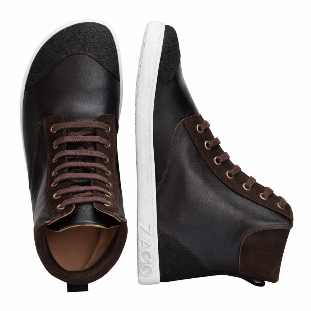 Ausgestellt werden zwei dunkelbraune MINSQ Mid-Cut-Sneaker von ZAQQ. Ein Sneaker steht aufrecht und weist eine weiße Sohle mit Branding auf, während der andere auf der Seite liegt und ein dunkelbraunes Obermaterial und passende Schnürsenkel zur Schau stellt.