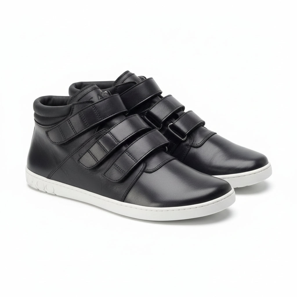 Ein Paar schwarze QOOPER High-Top-Sneaker von ZAQQ mit drei Klettverschlüssen, weißer Sohle und detaillierten Nähten. Das Barfuß-Design sorgt für ein angenehmes Tragegefühl. Sie sind kunstvoll nebeneinander auf einem sauberen, weißen Hintergrund positioniert.