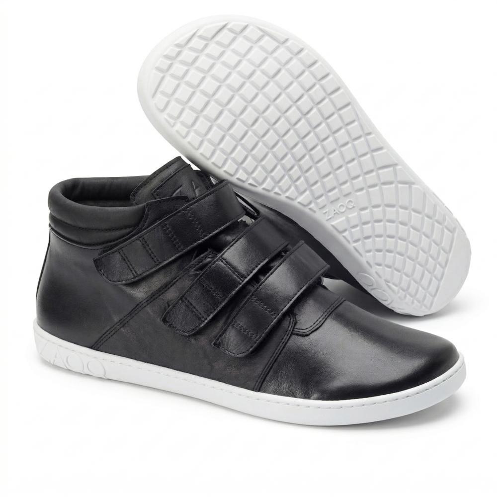 Ausgestellt wird ein Paar schwarze QOOPER High-Top-Sneaker von ZAQQ mit weißer Sohle. Ein Schuh steht aufrecht und hat drei Klettverschlüsse, während der andere angewinkelt ist, um das strukturierte Sohlenmuster hervorzuheben.