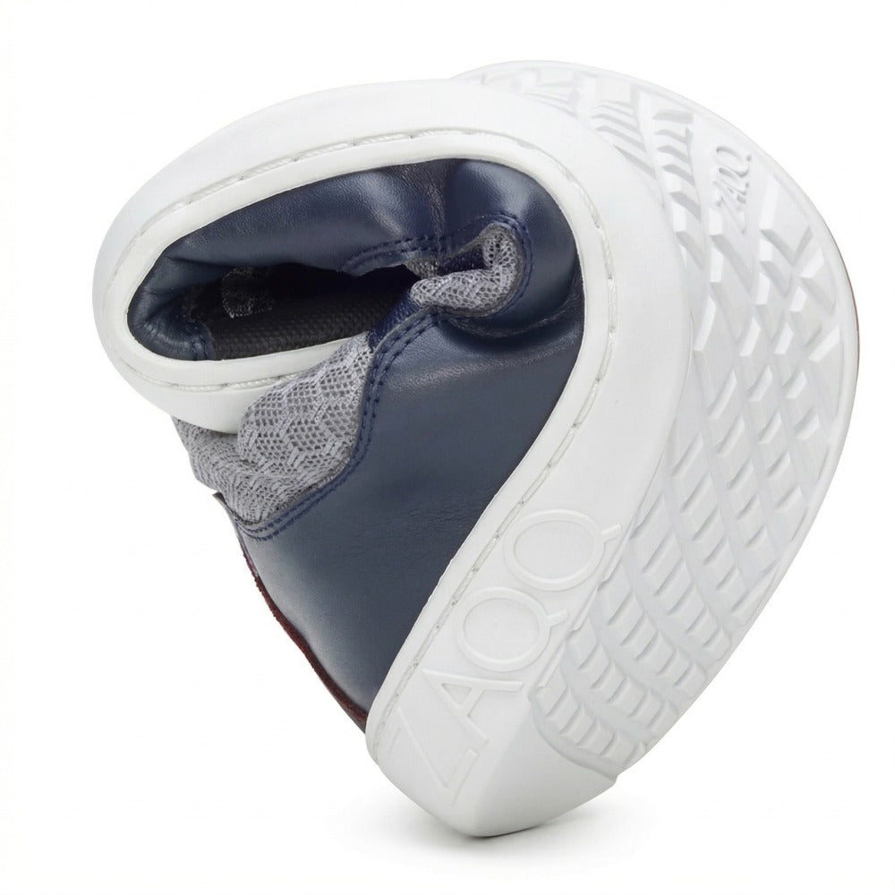 Der ZAQQ SQATE graue Damen-Sneaker, ein Barfußschuh, ist bemerkenswert flexibel und lässt sich leicht in der Mitte biegen. Mit seinem stilvollen marineblau-weißen Design und der strukturierten Sohle ist er ideal für den Alltag und trägt den Markennamen deutlich sichtbar auf der Ferse.